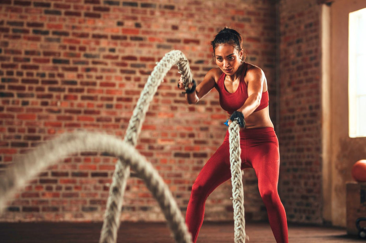 Kvinde træner med battle ropes